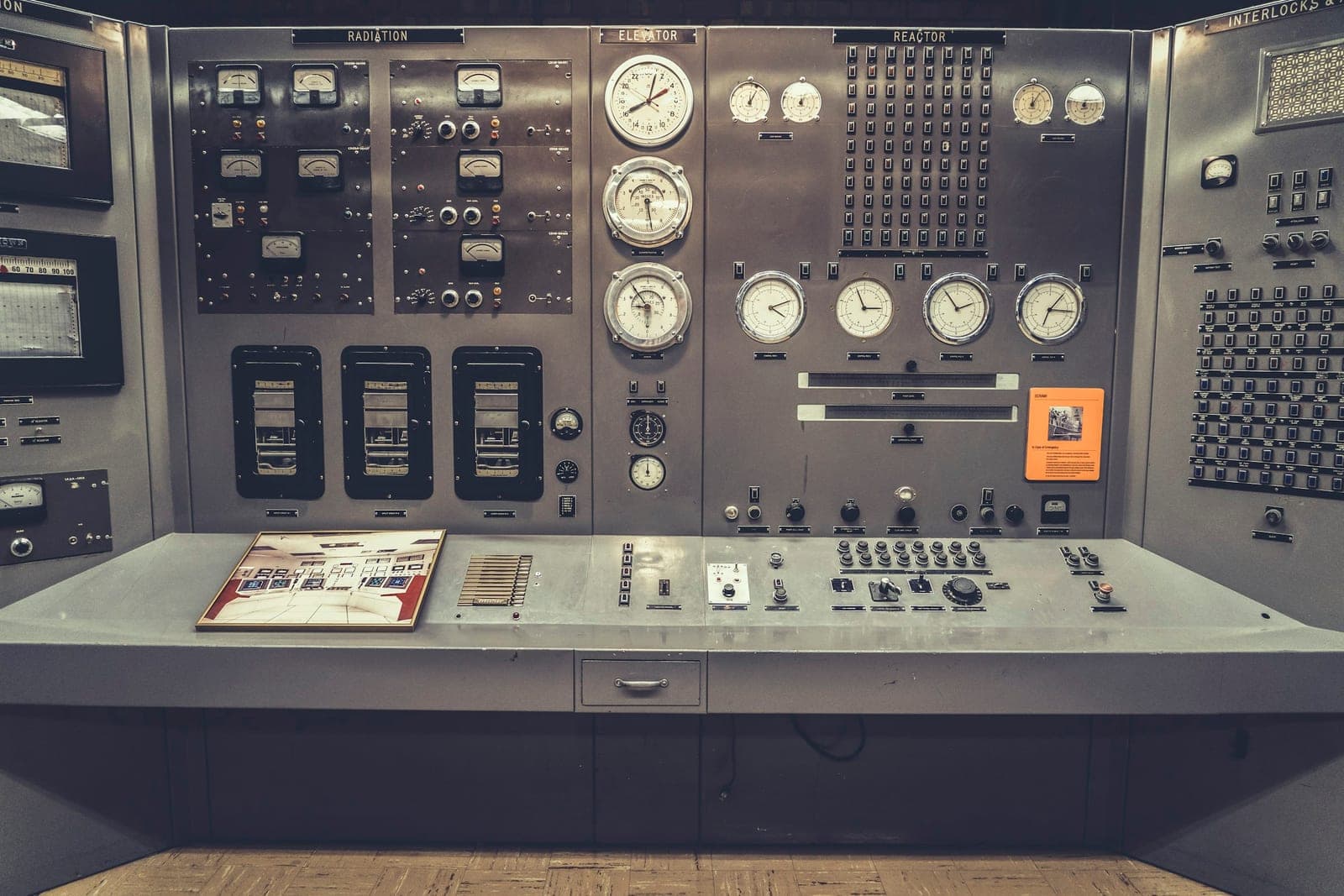 Reactor control console with radiation, reactor and interlock instrument panels above a bank of switches
